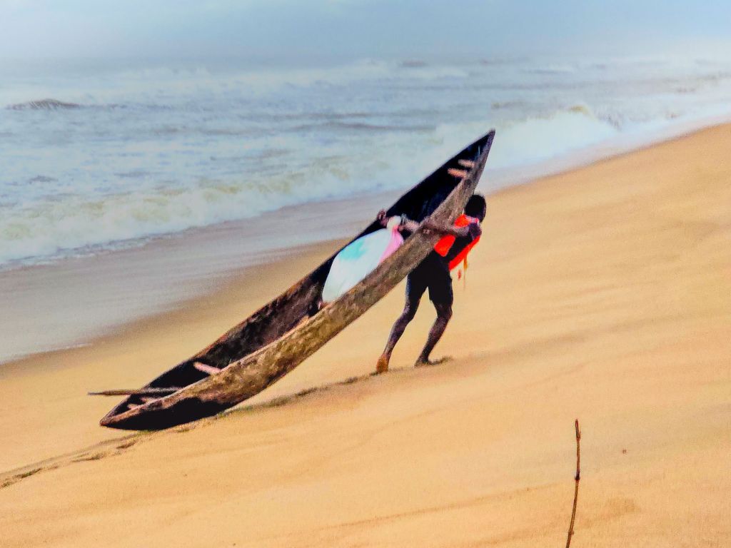 Fisherman carry his canoe, Mananjary, Madagascar